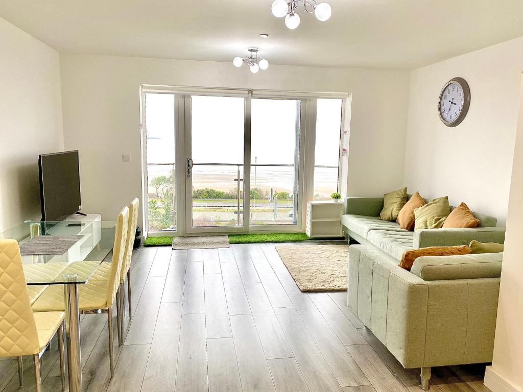 a living room with a couch and a table at Lovely New 2 Bedroom Condo with Stunning Seaviews in Penmaen-mawr