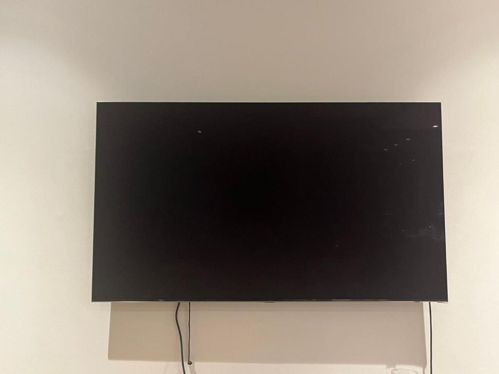 a flat screen tv sitting on a white wall at The AA WIFI in London