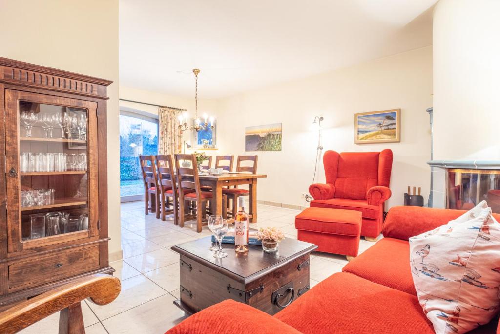 a living room with a red couch and a table at Dünenhof DÜNENHOF Whg. D-10 in Wustrow