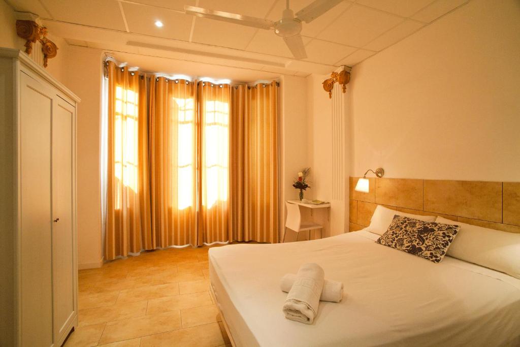 a white bed sitting in a bedroom next to a window at Hostal Martinval in Barcelona