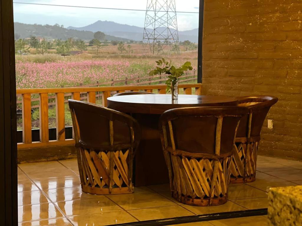 un tavolo e sedie su un portico con vista di Villa Rancho la Espuela a Tapalpa