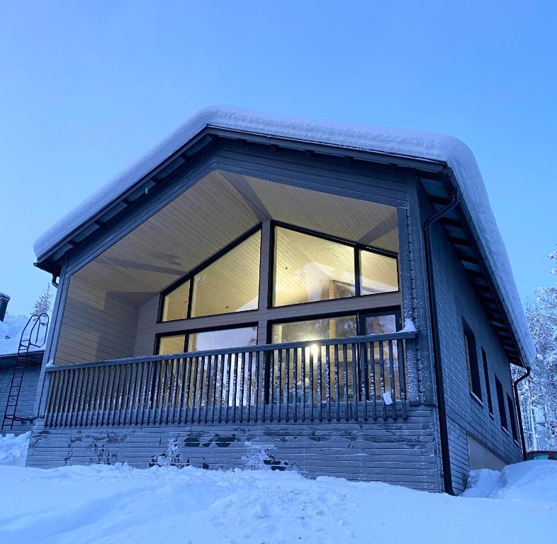 una casa con una gran ventana en la nieve en Villa Iiris - New Holiday Home, en Äkäslompolo