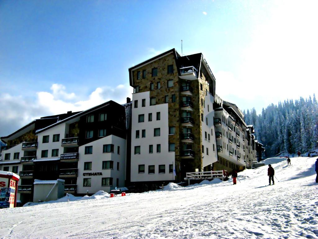 een groot gebouw op een skipiste in de sneeuw bij Stenata Boutique Apartments in Pamporovo