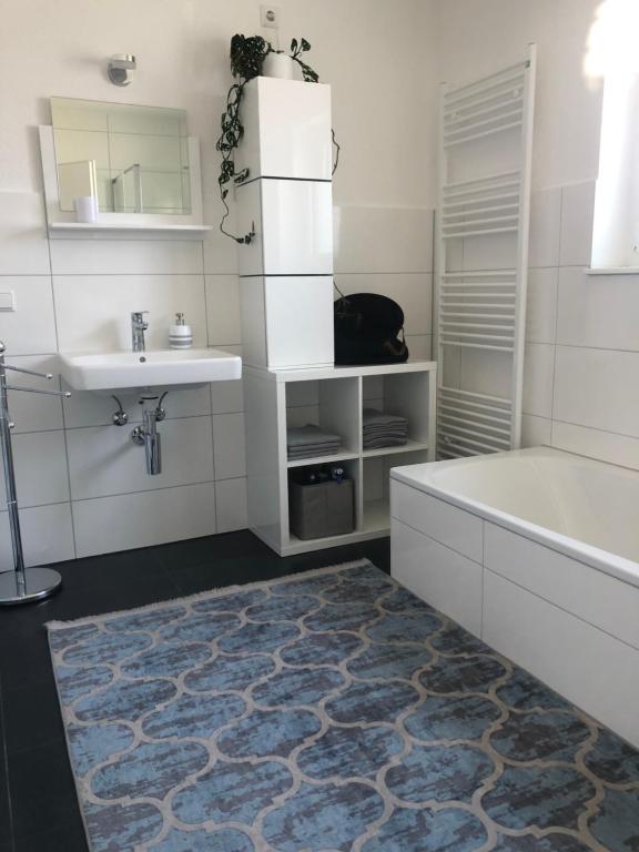 ein Badezimmer mit einer Badewanne, einem Waschbecken und einer Badewanne in der Unterkunft Zentrales City Penthouse in Friedrichshafen