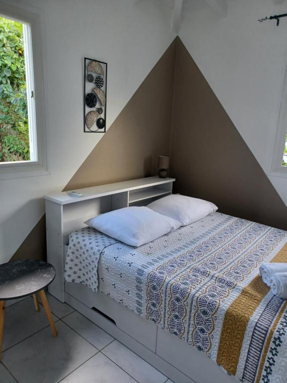 a bedroom with a bed with a triangular headboard at Nature & Zénitude - Morne-à-l'Eau 