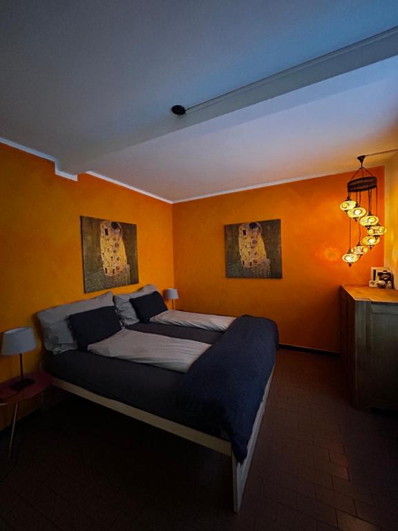 a bedroom with a large bed with orange walls at Charming Room in the heart of Locarno in Locarno