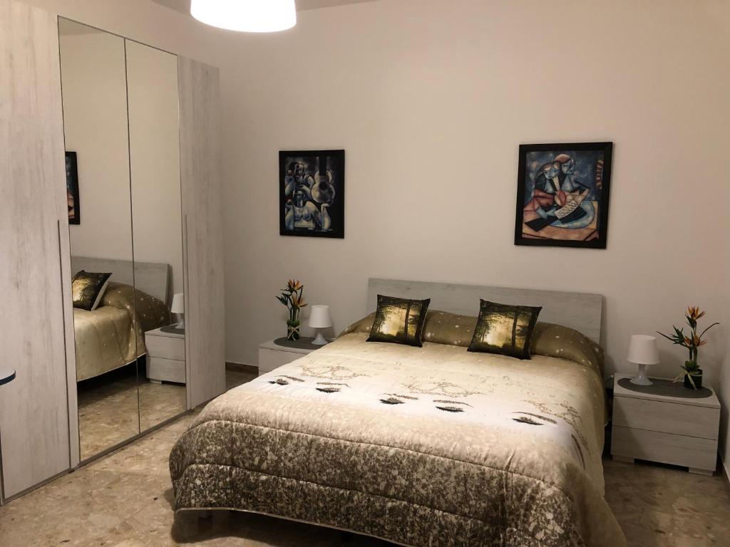 1 dormitorio con 1 cama grande y espejo en SMM Apartment, en Ferrara
