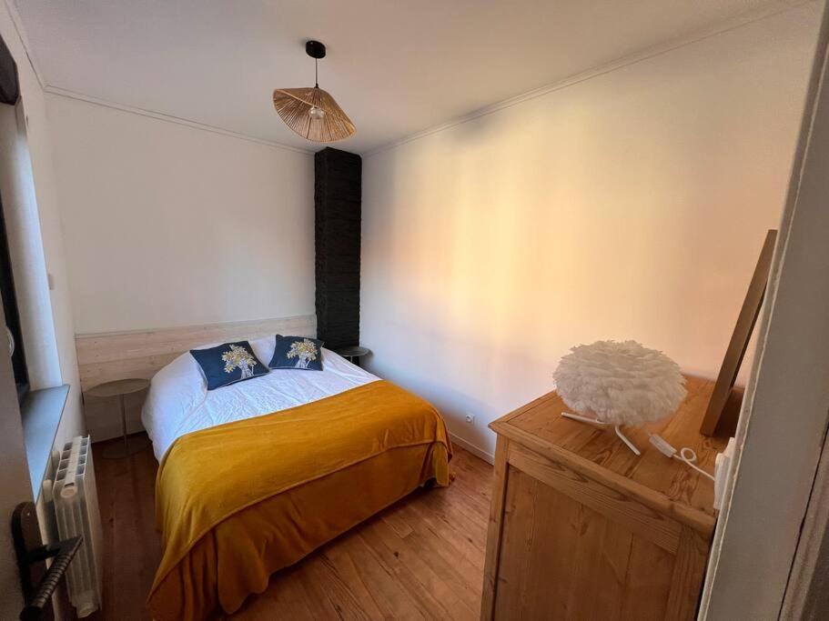 - une chambre avec un lit et une couverture jaune dans l'établissement Villa du parc au cœur de Malo, à Dunkerque