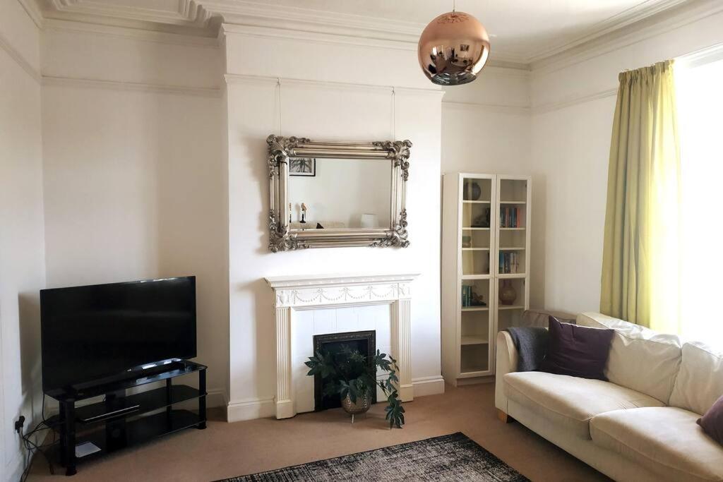 a living room with a couch and a mirror at Huge 5 bed Grade II listed home in heart of town in Exmouth