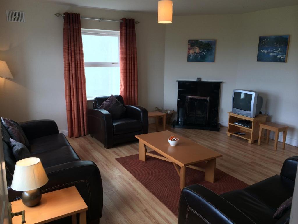 a living room with couches and a table and a tv at Doolin Village Lodges in Doolin