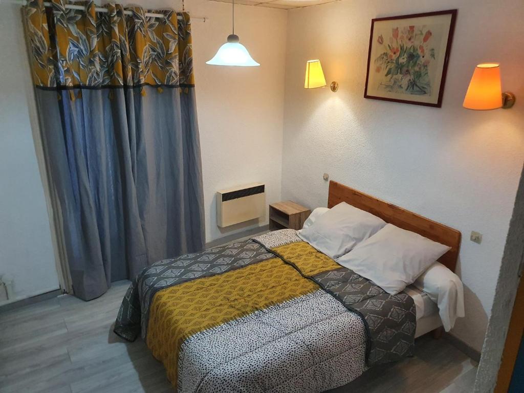 a bedroom with a bed and a television in it at Hôtel du Champs de Mars in Béziers