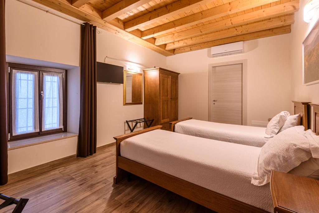 Łóżko lub łóżka w pokoju w obiekcie il Glicine B&B RISTORANTE