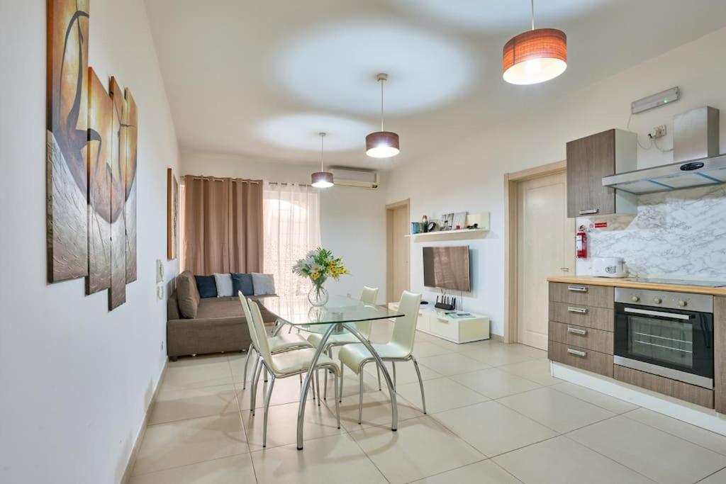 eine Küche und ein Wohnzimmer mit einem Tisch und Stühlen in der Unterkunft Depiro Point Sliema Luxury Apartment in Sliema