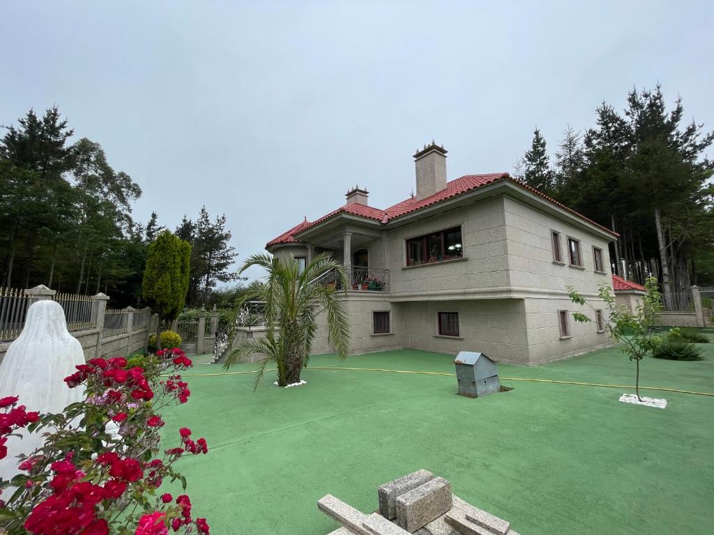 dom z kortem tenisowym przed nim w obiekcie Impresionante casa con parcela en la naturaleza w mieście A Coruña