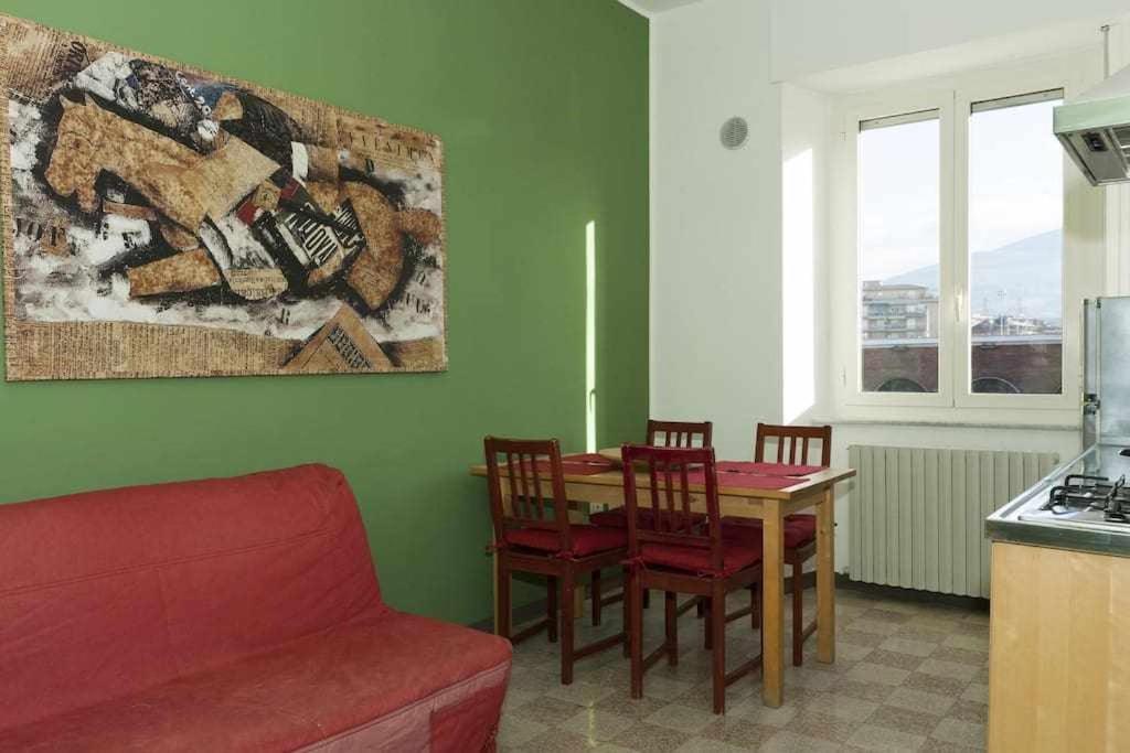 uma sala de estar com uma mesa e cadeiras e um sofá em Ospitaci Appartamenti Viale Mezzetti em Foligno