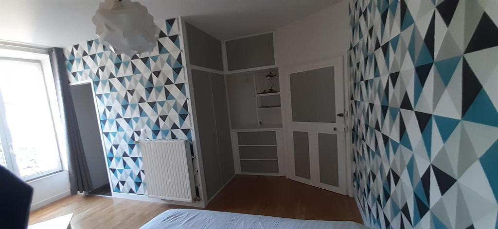 a room with a wall with blue and white tiles at Chambre tout confort à l&#39;étage in Conlie