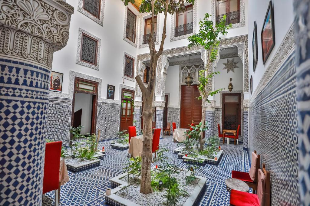 une cour avec un arbre au milieu d'un bâtiment dans l'établissement Riad Dari Fes, à Fès