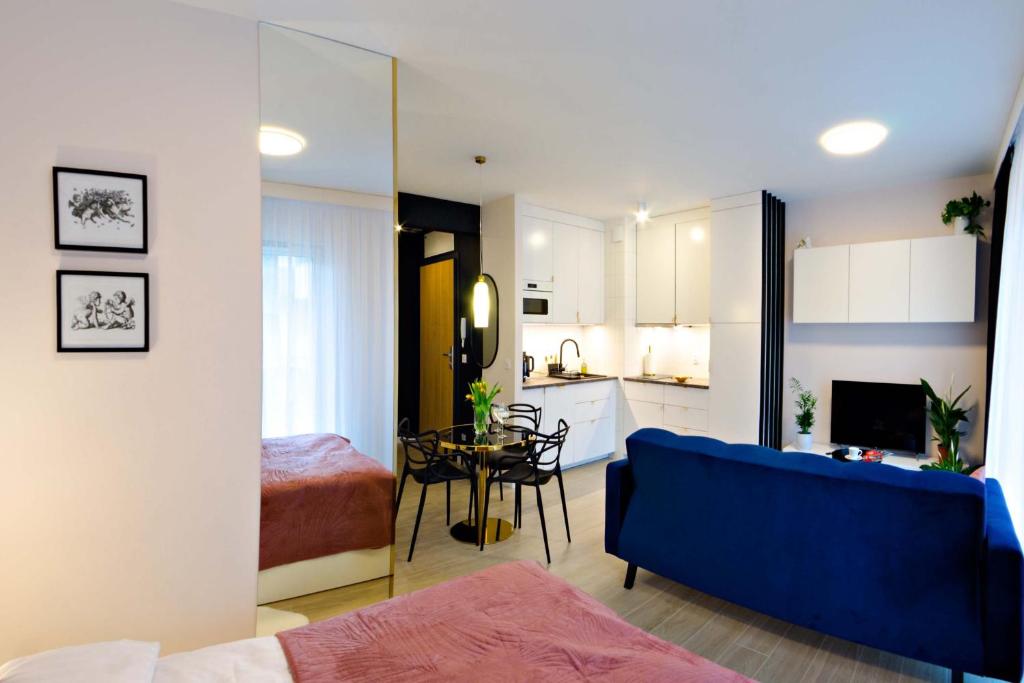 Il comprend un salon avec un canapé bleu et une cuisine. dans l'établissement Cherub Apartment, à Wrocław
