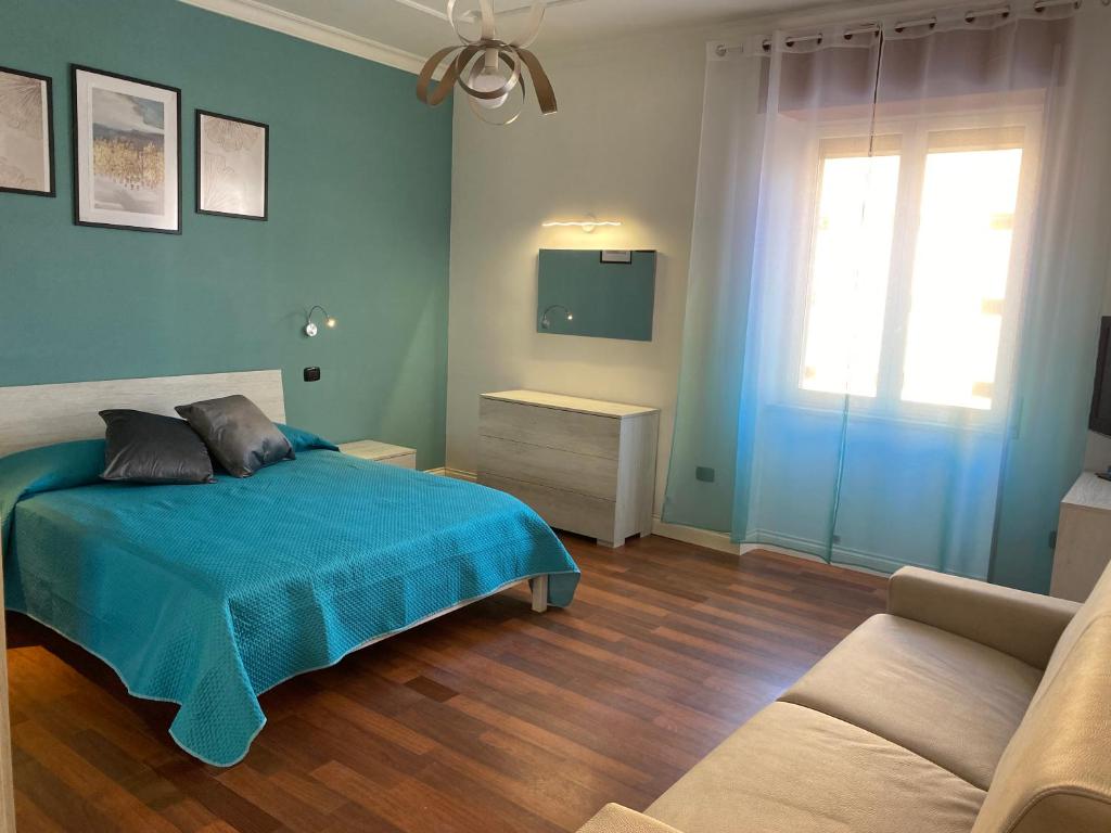 a bedroom with a bed and a couch and a window at L'Aurora Guest House in Castellammare di Stabia