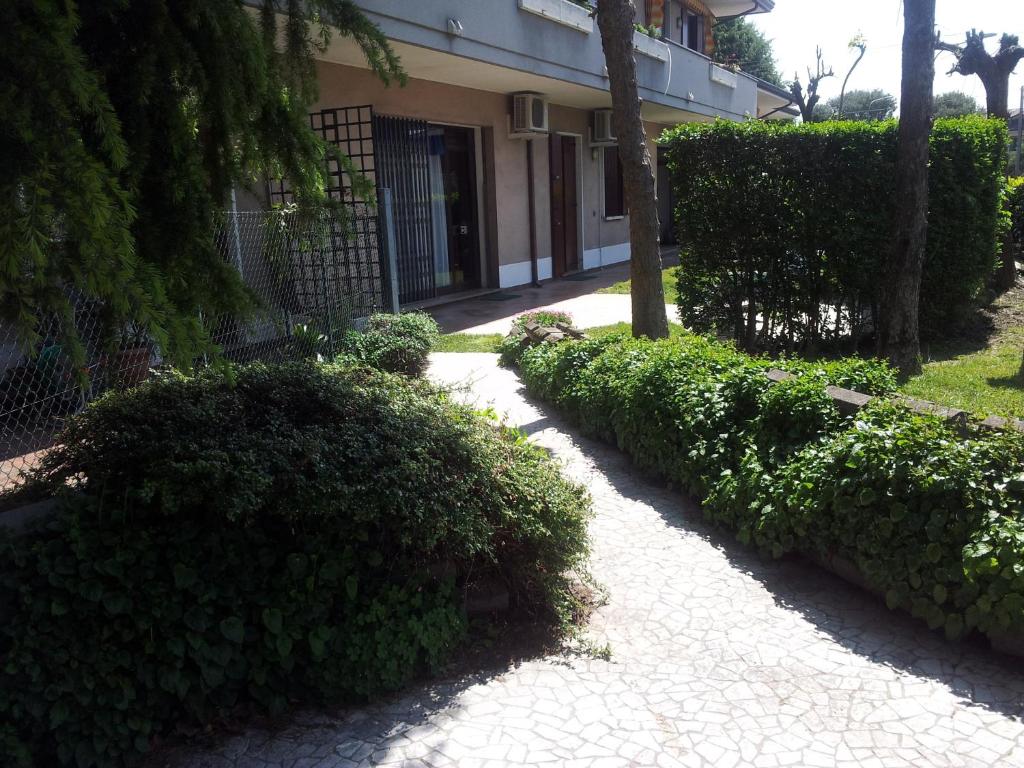 uma passagem em frente a um edifício com arbustos em B&B Il Centralino em Legnaro