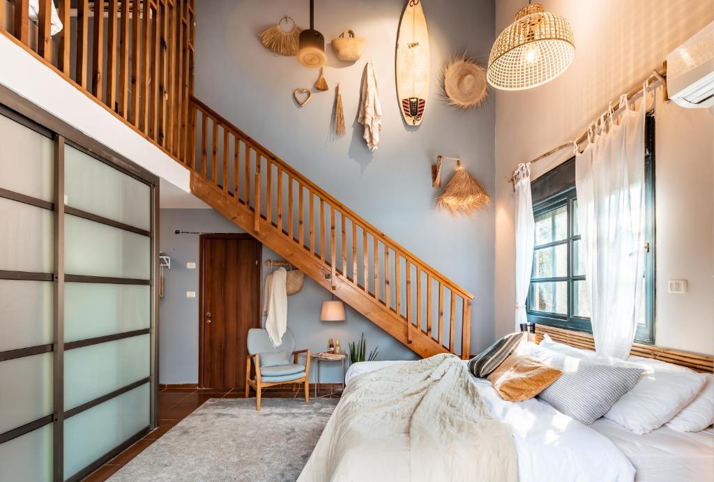 1 dormitorio con 1 cama y escalera en Dolphin Village - Sea Resort By Ran Hotels, en Shave Ẕiyyon