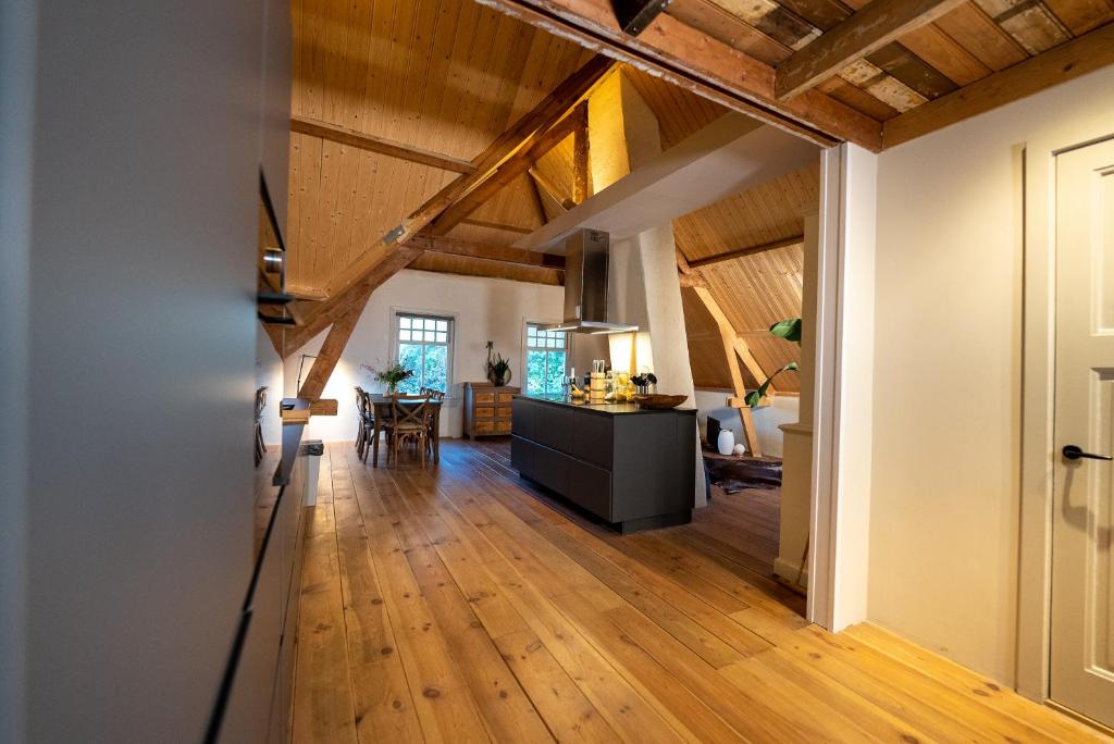 una sala de estar de planta abierta y una cocina con vigas de madera. en Stroeckmanhoeve, en Neede