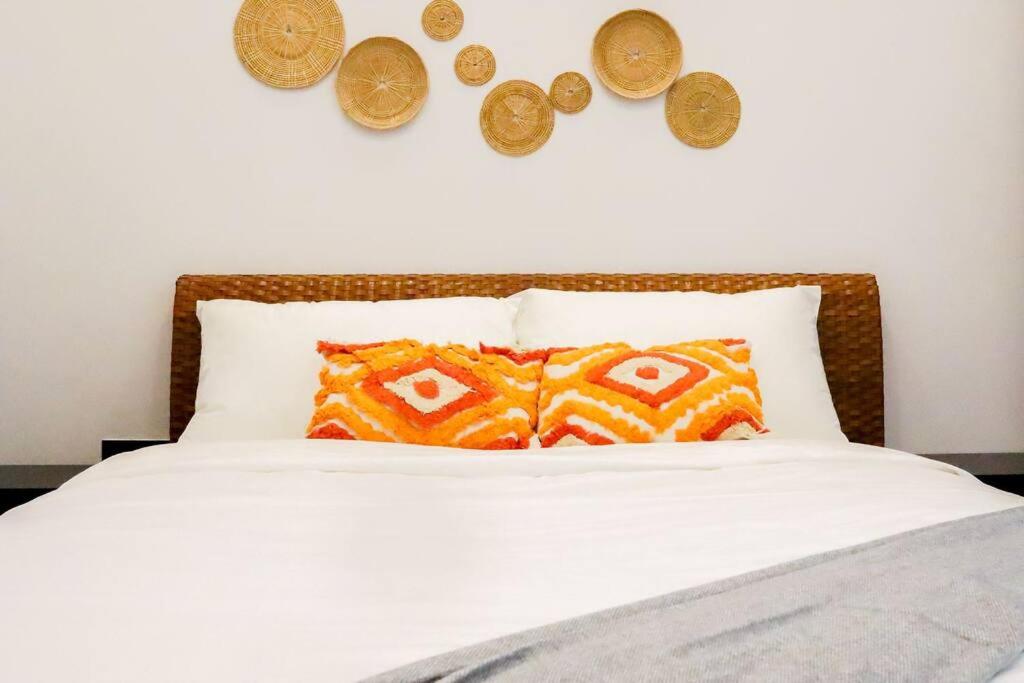 uma cama com duas moedas na parede e duas almofadas em Tanjung Jara Cottage - with indoor pool em Dungun
