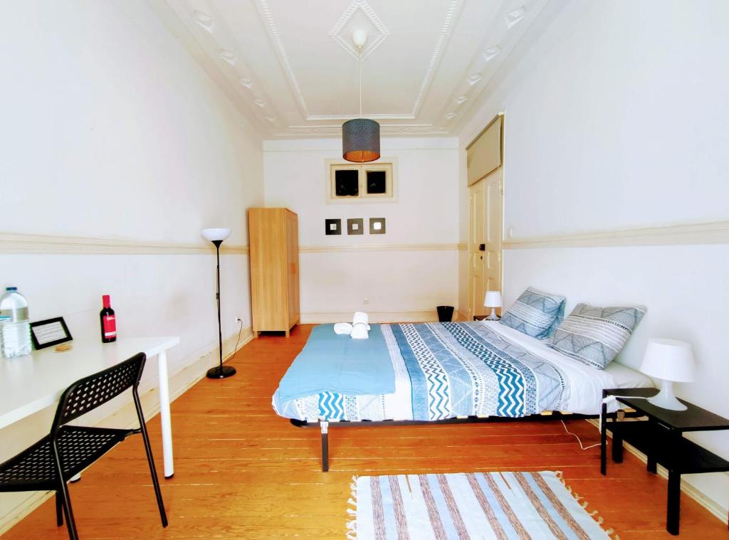 リスボンにあるFernando Pessoa Lisbon Roomsのベッドルーム1室(ベッド1台、テーブル、デスク付)