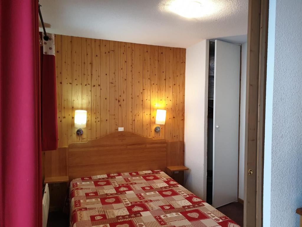 a bedroom with a bed and a wooden wall at Appartement valmeinier 6 personnes in Valmeinier