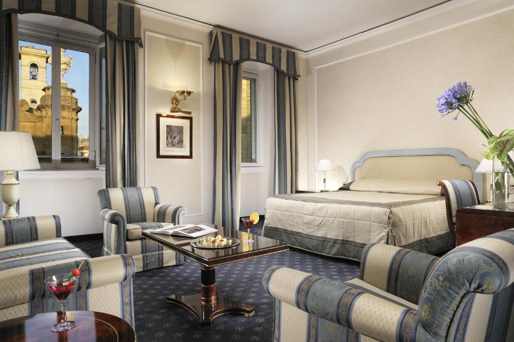 a hotel room with a bed and chairs at Hotel De La Ville in Florence