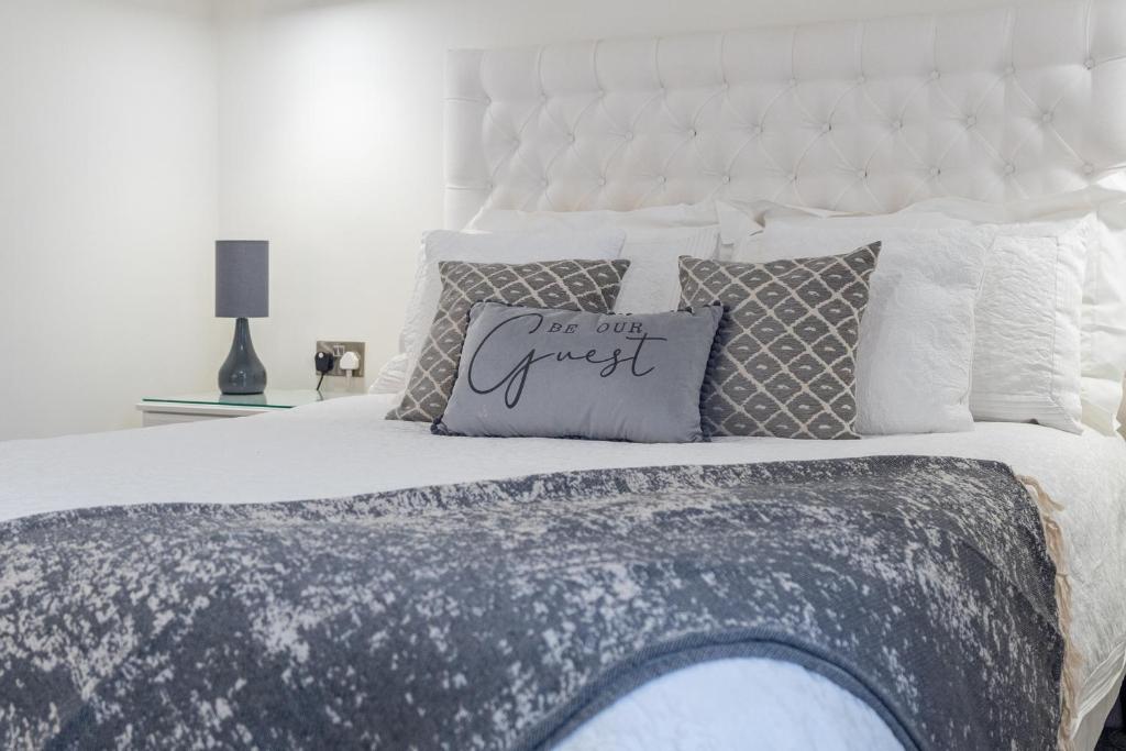 a white bed with a white headboard and pillows at The Hideaway in Chester