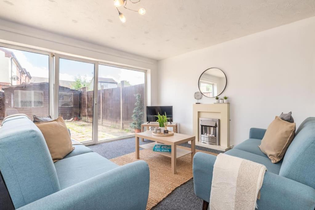 a living room with two blue chairs and a table at Whetstone House in Ketteringham