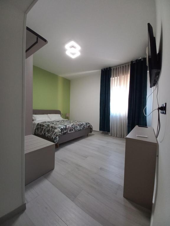 ein Schlafzimmer mit einem Bett und einem TV in der Unterkunft L.ADY HOME in Bologna