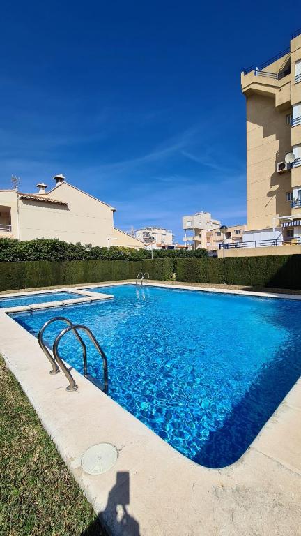 a large blue swimming pool next to a building at Oliva Moon in Oliva