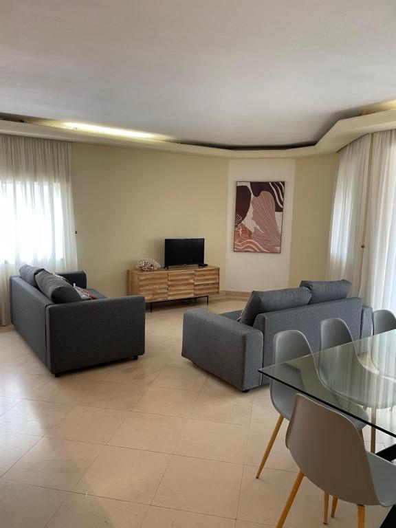uma sala de estar com sofás, uma mesa e uma televisão em Relax Beach Home - Costa de Caparica - Sea View em Costa da Caparica
