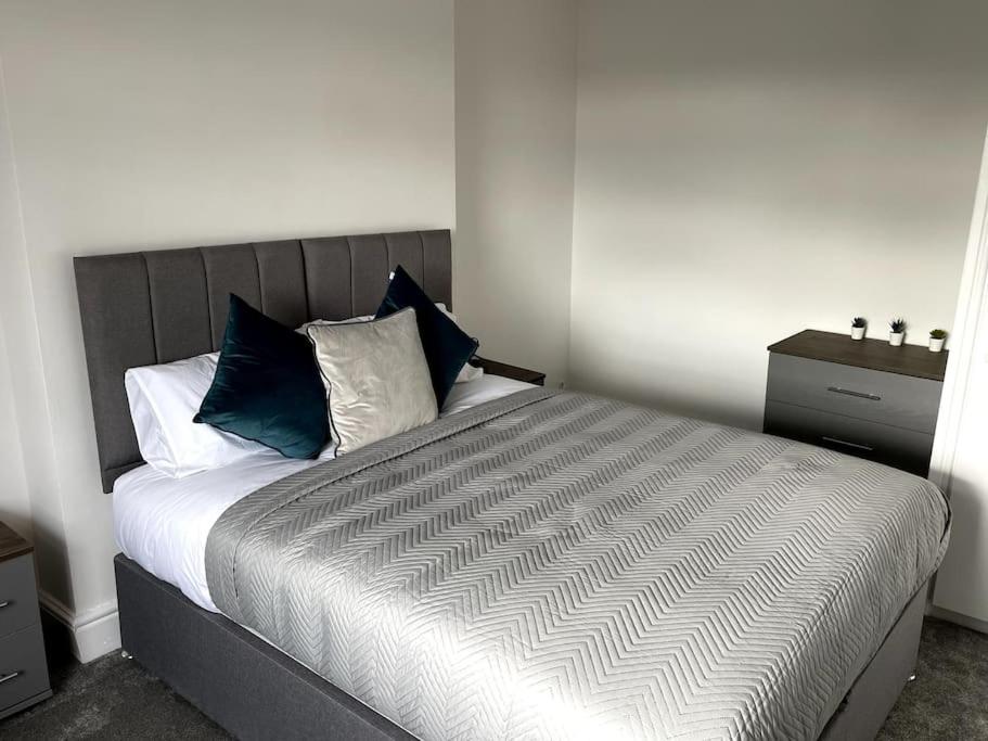 a bedroom with a bed with blue and white pillows at Priestley Apartments Ap 2 in Nantwich