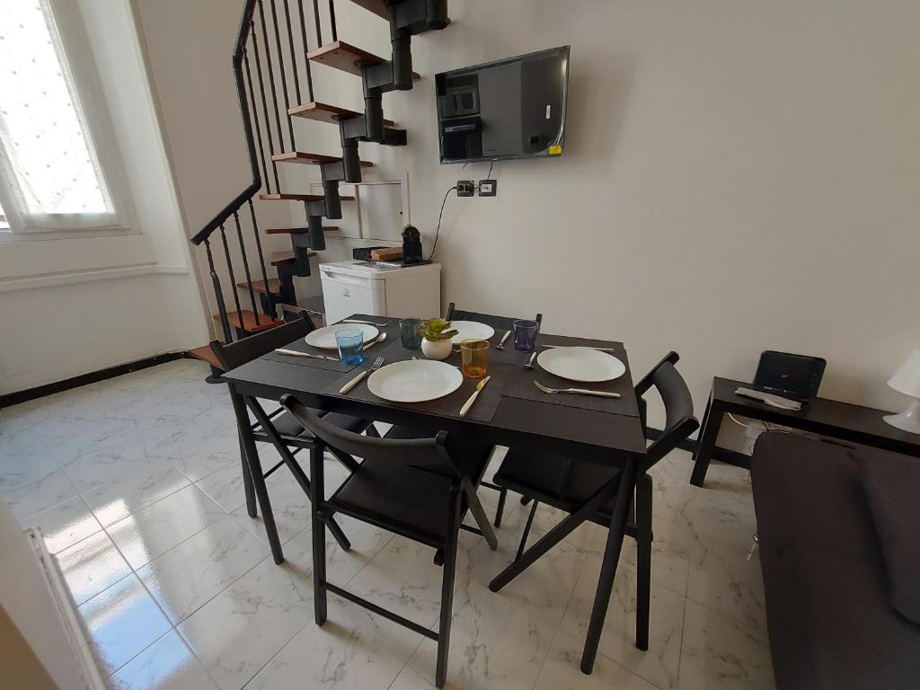 une salle à manger avec une table et des chaises et un escalier dans l'établissement Corso Genova - Milano Navigli, à Milan