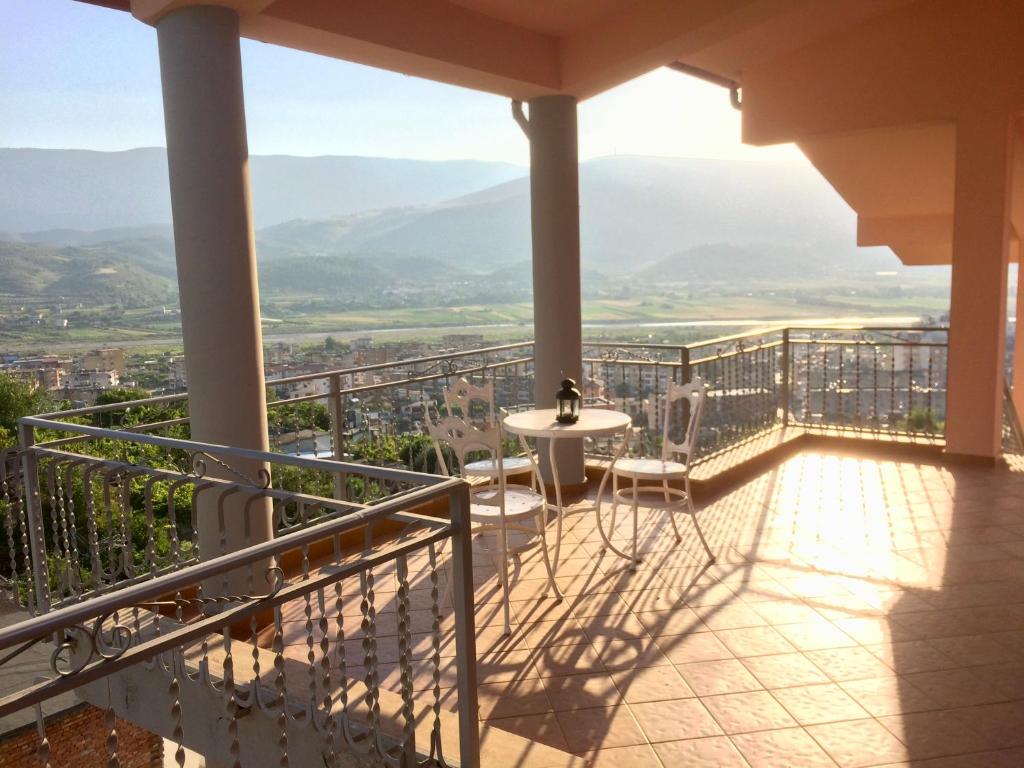 balcón con mesa, sillas y vistas en Guesthouse Villa Rosa Berat, en Berat