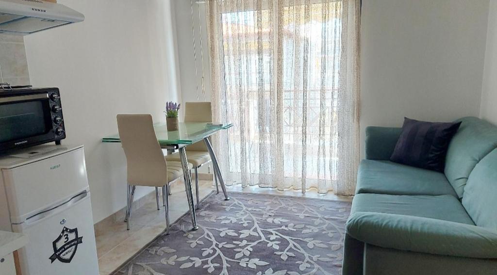 a living room with a table and a blue couch at FBM Anagenessis - Ευ Ζην in Edessa