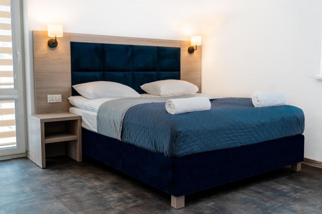 um quarto com uma grande cama azul e 2 almofadas em Lynks Resort em Ustrzyki Dolne