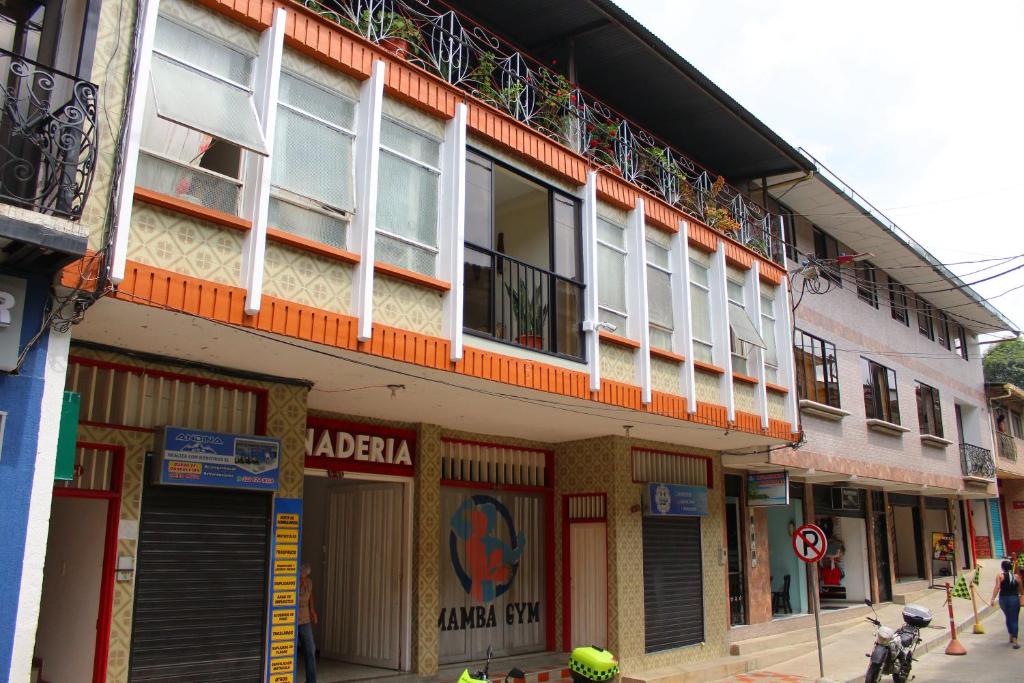 Hotel Paucura في Pácora: مبنى بلكونات على جانب شارع