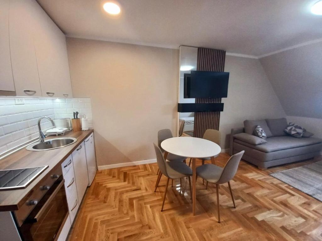 a small kitchen with a table and a couch at Gondola Apartments in Jahorina