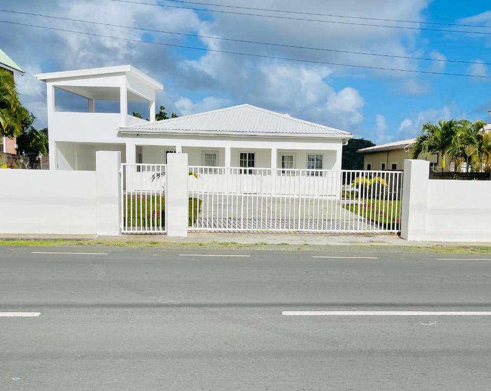 uma cerca branca em frente a uma casa branca em SALT ST LUCIA em Vieux Fort
