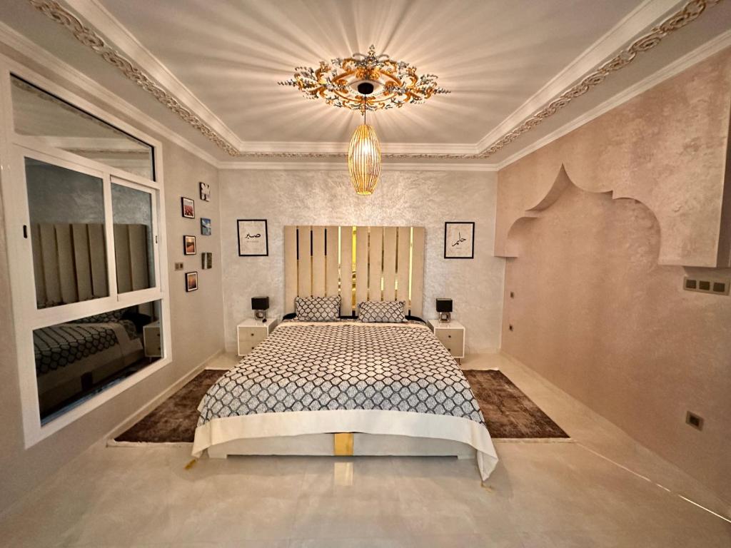 a bedroom with a bed and a chandelier at Villa Koebi in Monte ʼArrouit