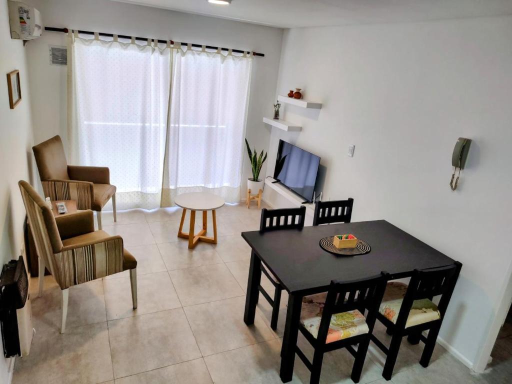sala de estar con mesa, sillas y TV en Bombal Sur en Godoy Cruz
