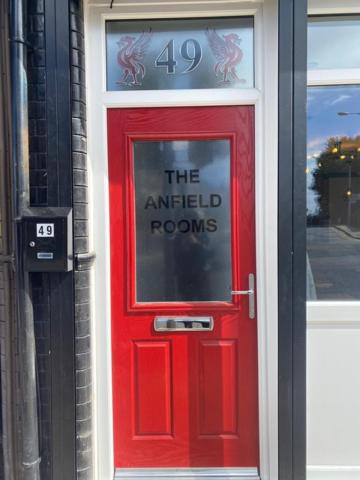 eine rote Tür mit einem Schild, das die Antfield-Zimmer liest in der Unterkunft The Anfield Rooms in Liverpool