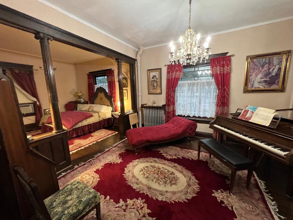 ein Wohnzimmer mit einem Klavier und einem Bett in der Unterkunft Bed and Breakfast Hearts Desire in Raton