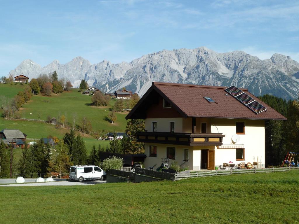 a house on a hill with mountains in the background at Ferienhaus Almfrieden in Schladming