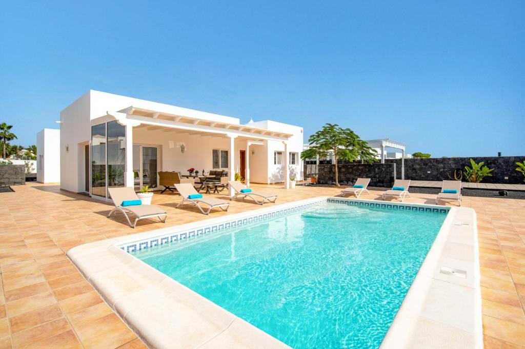 a villa with a swimming pool in front of a house at Villa Oscar Lanzarote by Villa Plus in Teguise