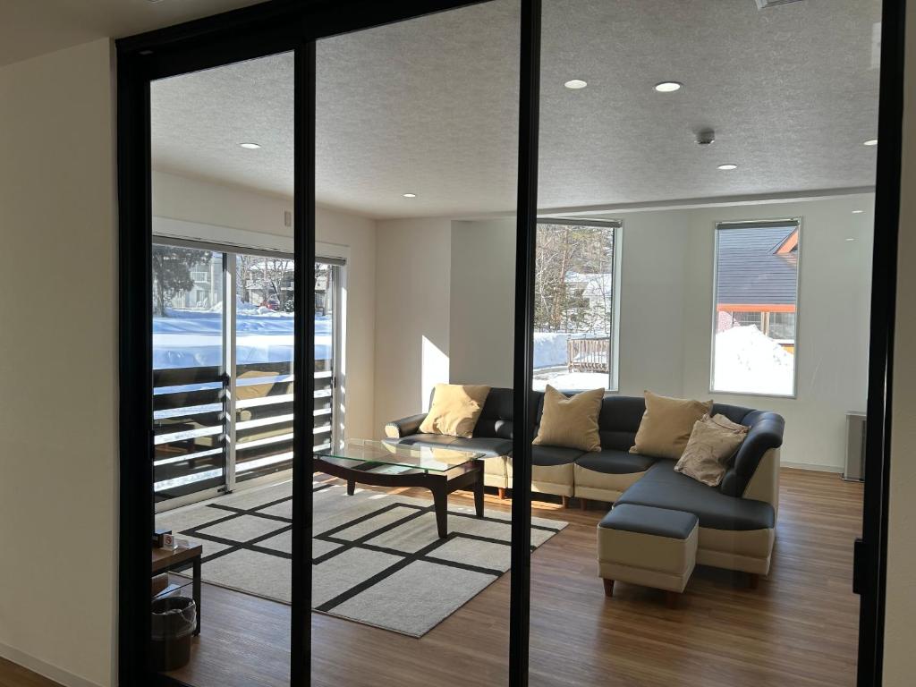 a living room with a couch and a table at Hakuba Sunrise Apartments in Hakuba